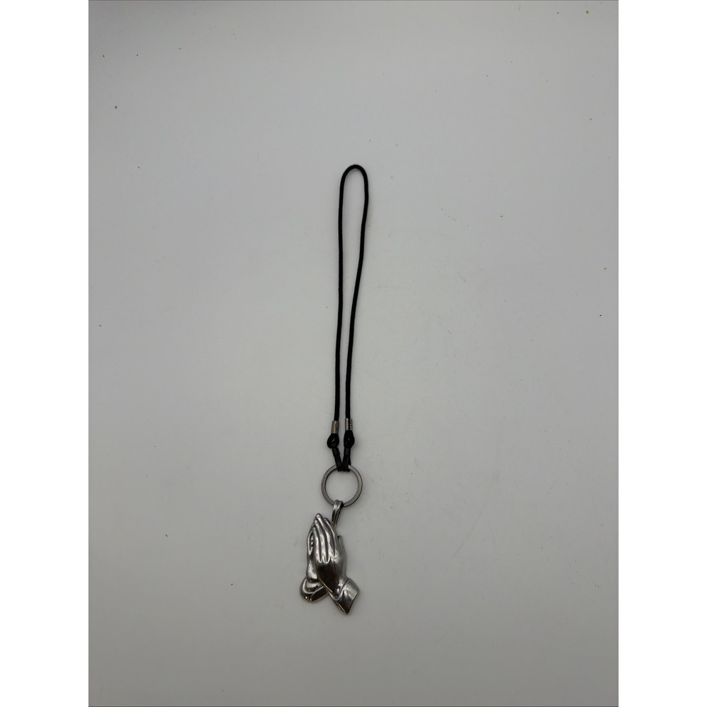 silver-toned praying hands pendant features a polished metal finish